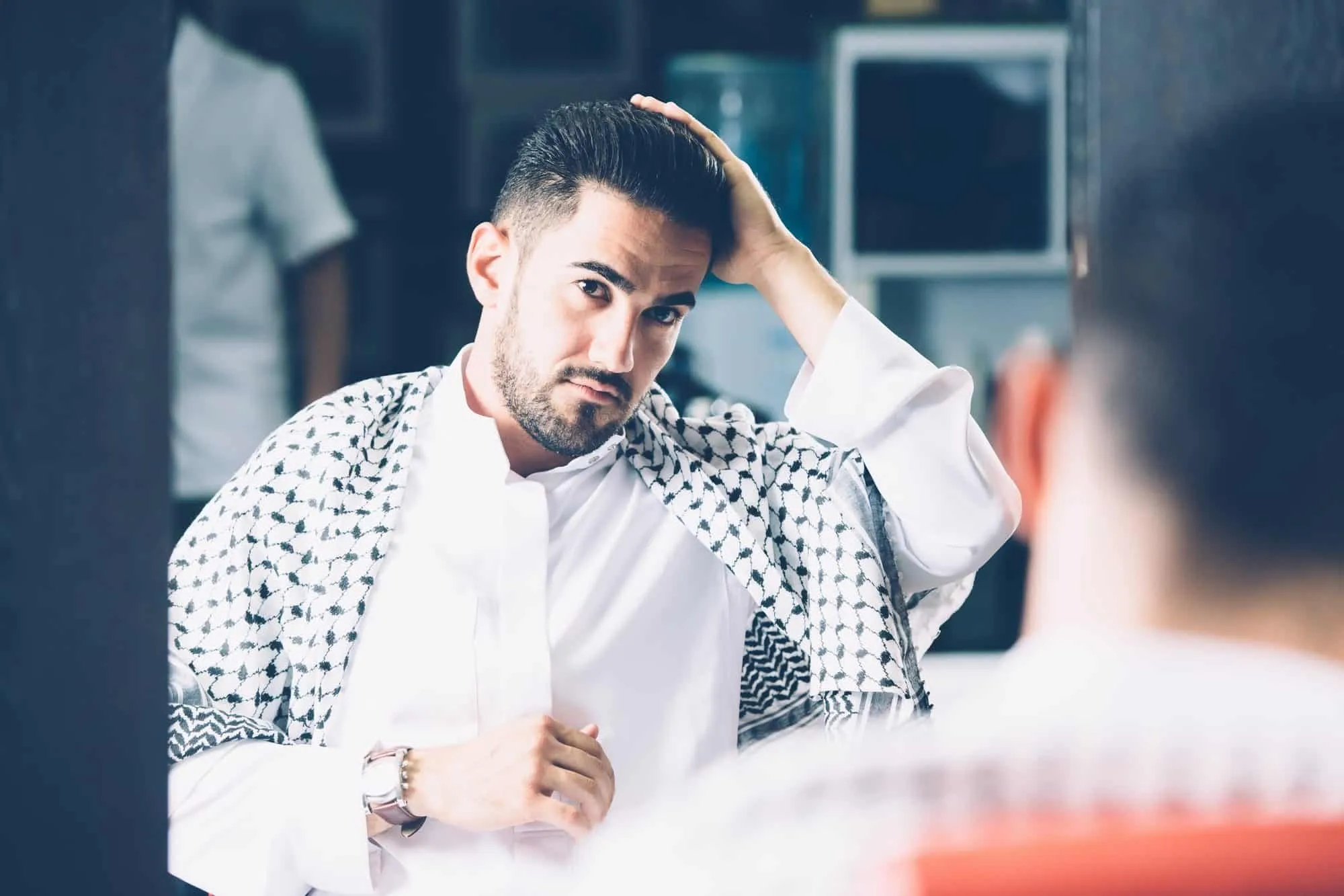 Man touching hair in barbershop